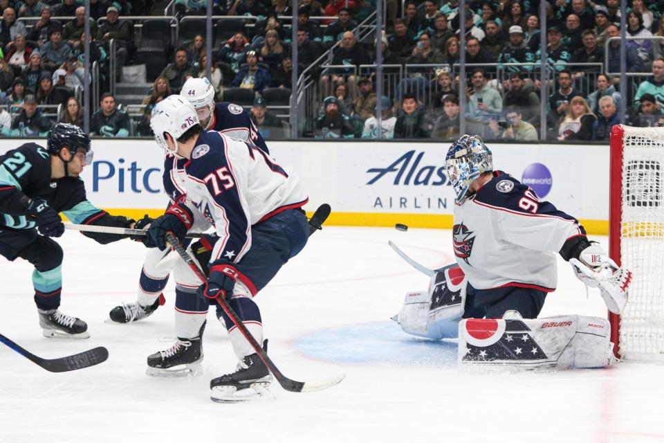 Seattle Kraken center Alex Wennberg (21) shoots the puck and scores on Columbus Blue Jackets goaltender Elvis Merzlikins (90) during the second period of an NHL hockey game Saturday, Jan. 28, 2023, in Seattle. (AP Photo/Jason Redmond)