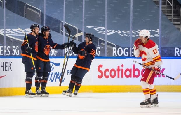 Edmonton Oilers' Connor McDavid (97), Ethan Bear (74) and Kailer Yamamoto (56) celebrate a goal on Saturday. (Jason Franson/The Canadian Press - image credit)