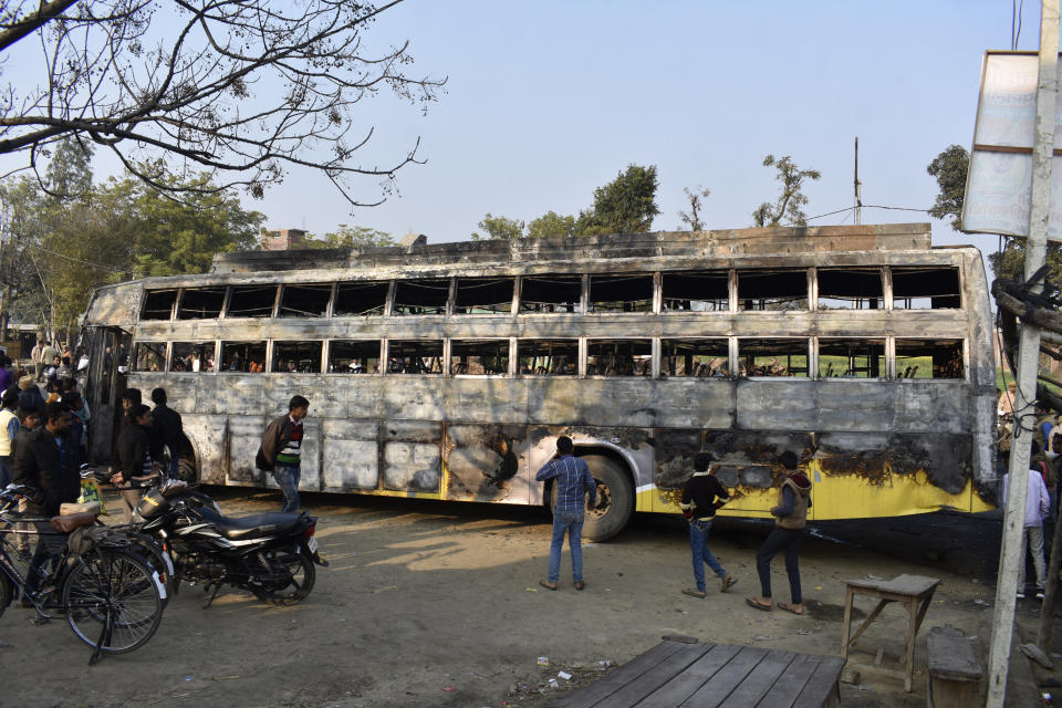 People look at the charred remains of a bus that caught fire after ramming into a truck in Kannauj, in the northern Indian state of Uttar Pradesh, Saturday, Jan. 11, 2020. At least 20 people died when in the accident, police said. Another 21 people were taken to a hospital, some of them in critical condition, following the crash late Friday, said senior police officer Mohit Aggarwal. (AP Photo)