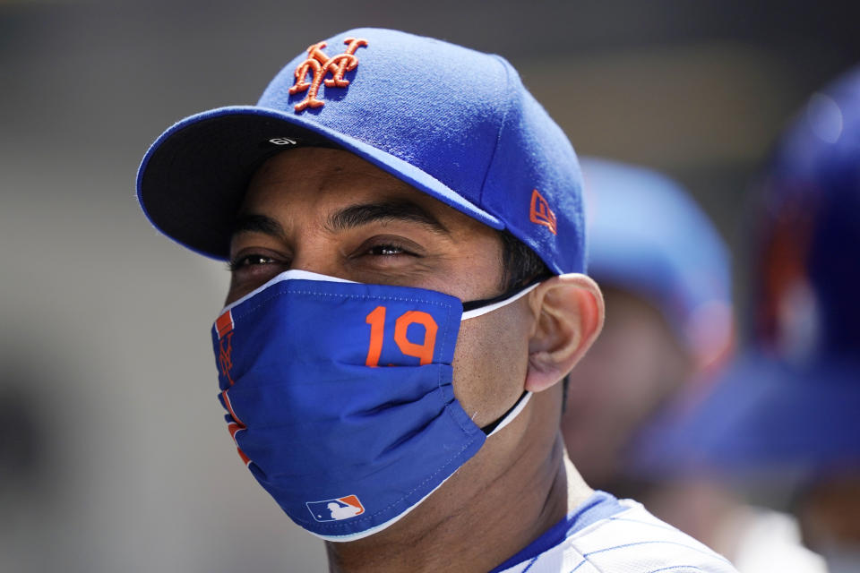 New York Mets manager Luis Rojas (19) appears to smile beneath his mask between innings of the Mets 7-1 victory over the Baltimore Orioles in a baseball game, Wednesday, May 12, 2021, in New York. The Mets swept the Orioles in a two-game series. (AP Photo/Kathy Willens)