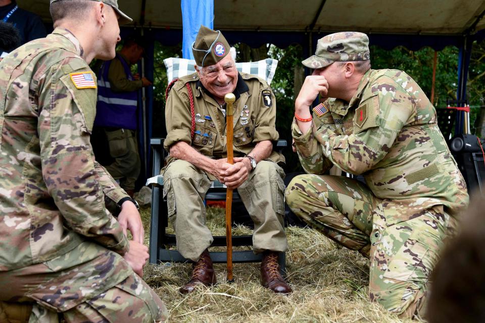 U.S. veteran paratrooper veteran Vincent Speranza speaks with a soldier in 2019 as they attend a parachute drop from seven C-47 aircraft over north-western France as part of D-Day commemorations marking the 75th anniversary of the World War II Allied landings in Normandy.