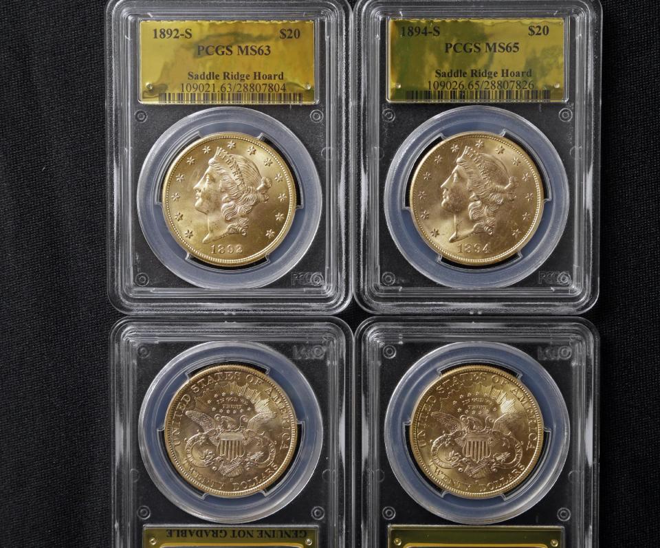 Four of 1,427 Gold-Rush era U.S. gold coins are displayed at Professional Coin Grading Service in Santa Ana, Calif., Tuesday, Feb. 25, 2014. A California couple out walking their dog on their property stumbled across the modern-day bonanza: $10 million in rare, mint-condition gold coins buried in the shadow of an old tree. Nearly all of the 1,427 coins, dating from 1847 to 1894, are in uncirculated, mint condition, said David Hall, co-founder of Professional Coin Grading Service, who recently authenticated them. Although the face value of the gold pieces only adds up to about $27,000, some of them are so rare that coin experts say they could fetch nearly $1 million apiece. (AP Photo/Reed Saxon)