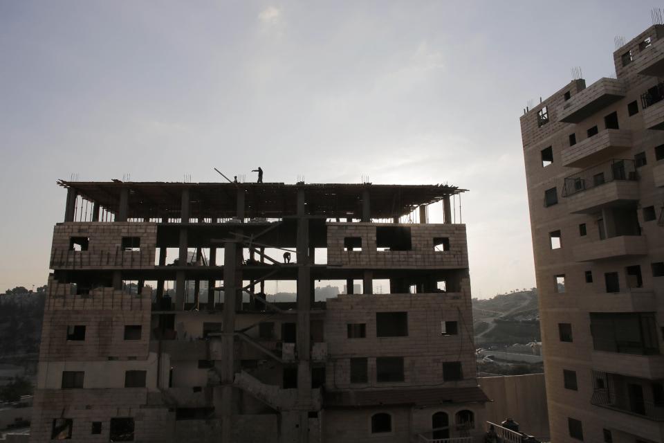 Labourers work at a construction site in the Shuafat refugee camp in the West Bank near Jerusalem