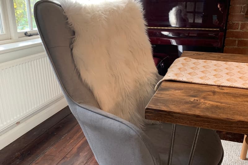 Grey armchair under dining table before painting.