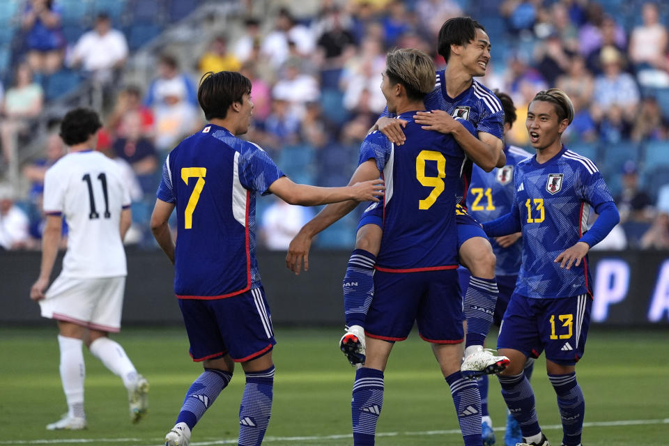 Japan forward Shota Fujio (9) celebrates with teammates after scoring a goal on a penalty kick during the first half of an international friendly under-23 soccer match against the United States Tuesday, June 11, 2024, in Kansas City, Kan. (AP Photo/Charlie Riedel)