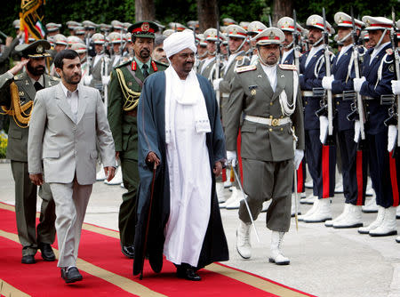 FILE PHOTO: Iranian President Mahmoud Ahmadinejad (front L) walks with his Sudanese counterpart Omar Hassan al-Bashir before an official meeting in Tehran, Iran April 24, 2006. REUTERS/Raheb Homavandi/File Photo