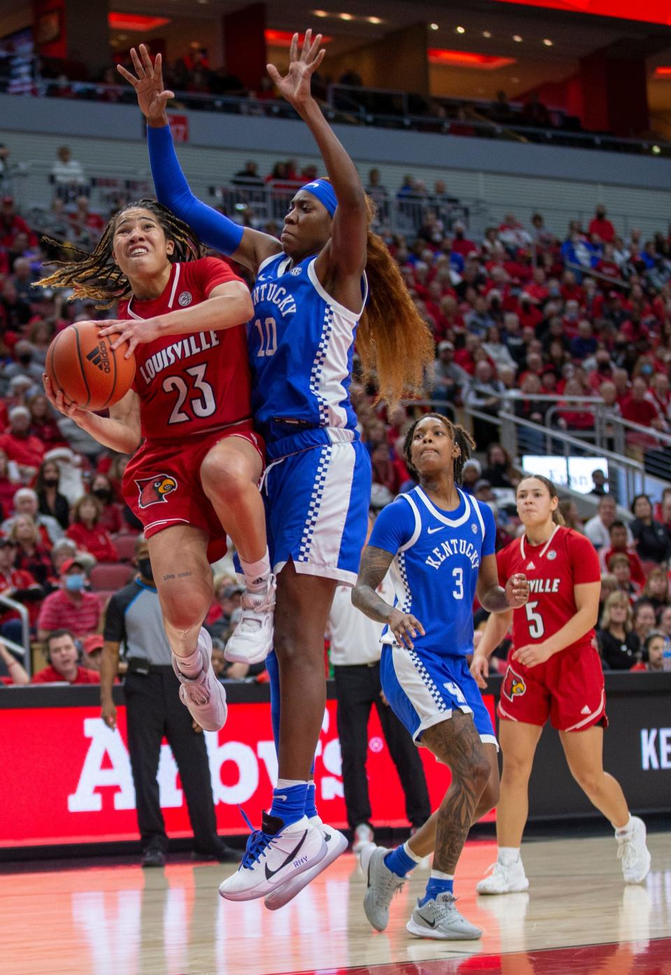 Louisville's Chelsie Hall drives to the basket against Kentucky's Rhyne Howard at the YUM Center. Dec. 12, 2021