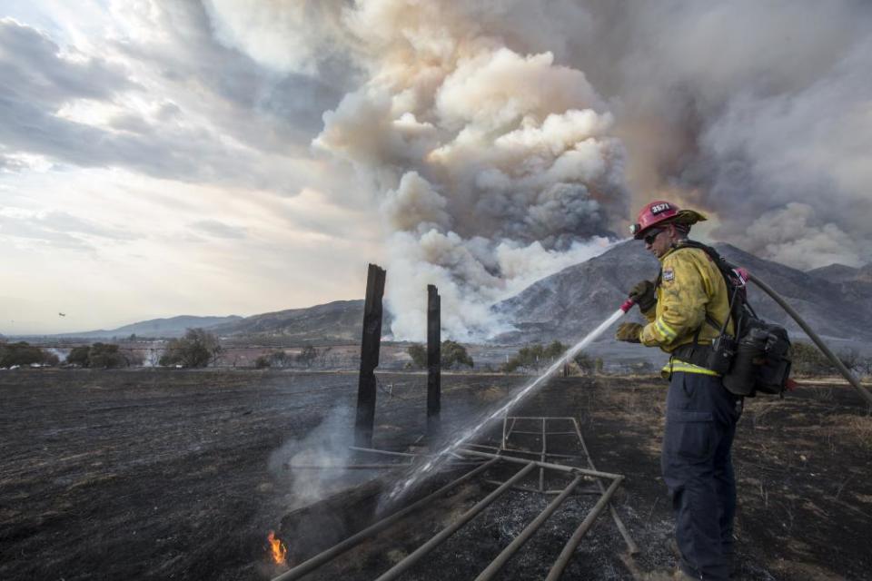 A firefighter works on hotspot at a wildfire in Yucaipa, California.