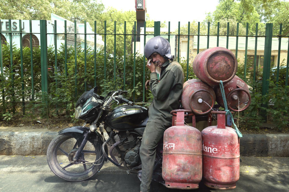 A gas cylinder delivery person wipes his sweat as takes a breather in the shade of a tree on a hot summer day in New Delhi, India, Monday, May 27, 2024. (AP Photo/Manish Swarup)