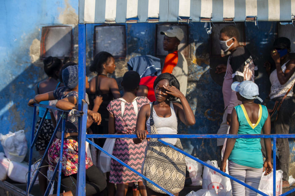 Lina André looks out from the entrance of the National Penitentiary where she waits to deliver food for her boyfriend who is incarcerated there, in Port-au-Prince, Haiti, Monday, Jan. 25, 2021. Her boyfriend has been incarcerated for 10 years but hasn’t seen a judge since he was arrested on suspicion of killing a man. (AP Photo/Dieu Nalio Chery)