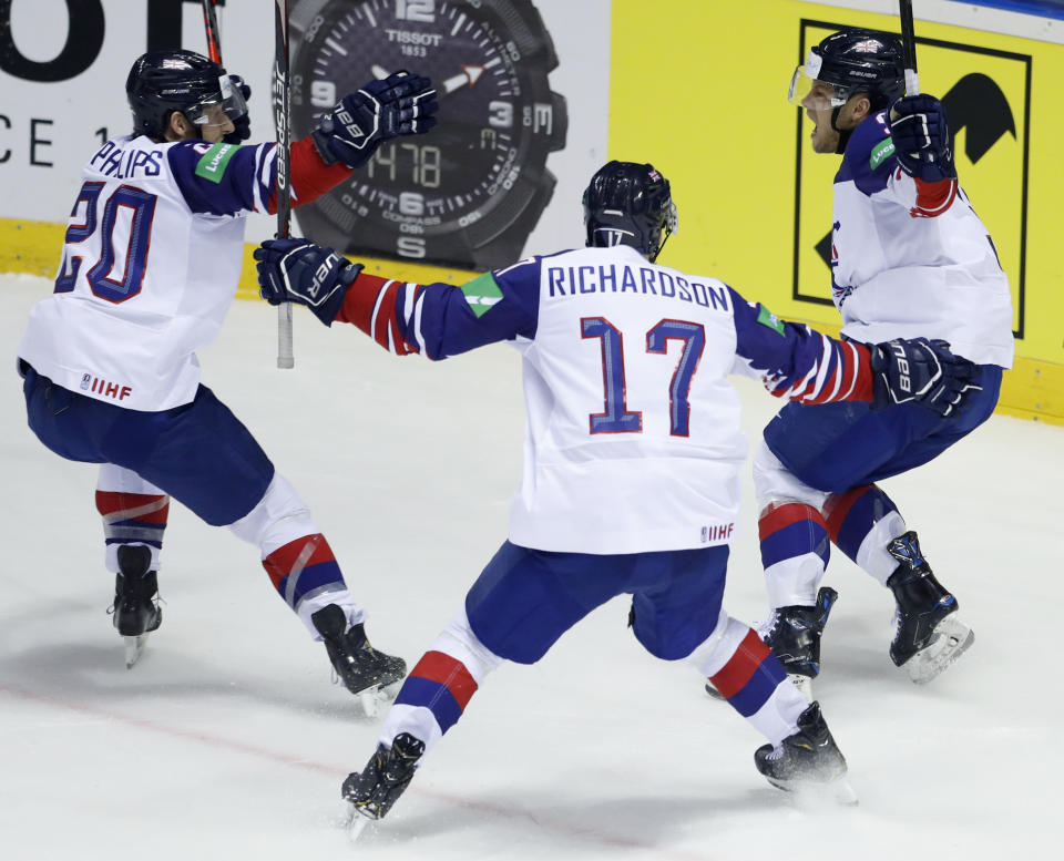 Great Britain's Ben Davies, right, celebrates with teammates Mark Richardson, center, and Jonathan Phillips, left, after scoring his sides winning goal during the Ice Hockey World Championships group A match between France and Great Britain at the Steel Arena in Kosice, Slovakia, Monday, May 20, 2019. (AP Photo/Petr David Josek)