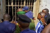 Congolese security officers look at a broken window at the Kangbayi central prison in Beni