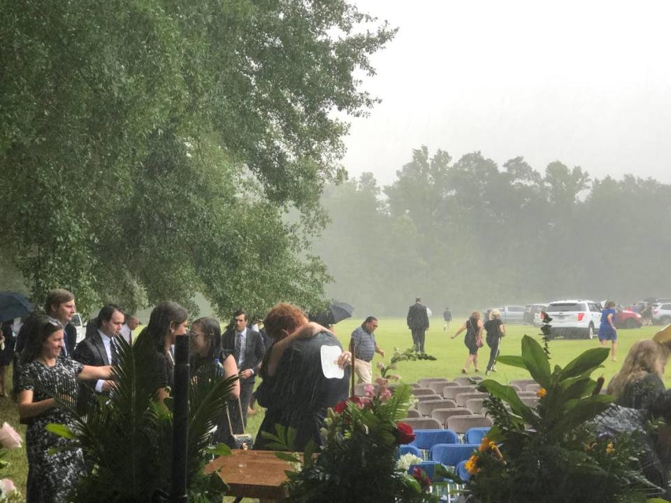 Buster Murdaugh receives a hug in the pouring rain at the funeral service for his brother, Paul, and mother, Maggie, on June 11, 2021.