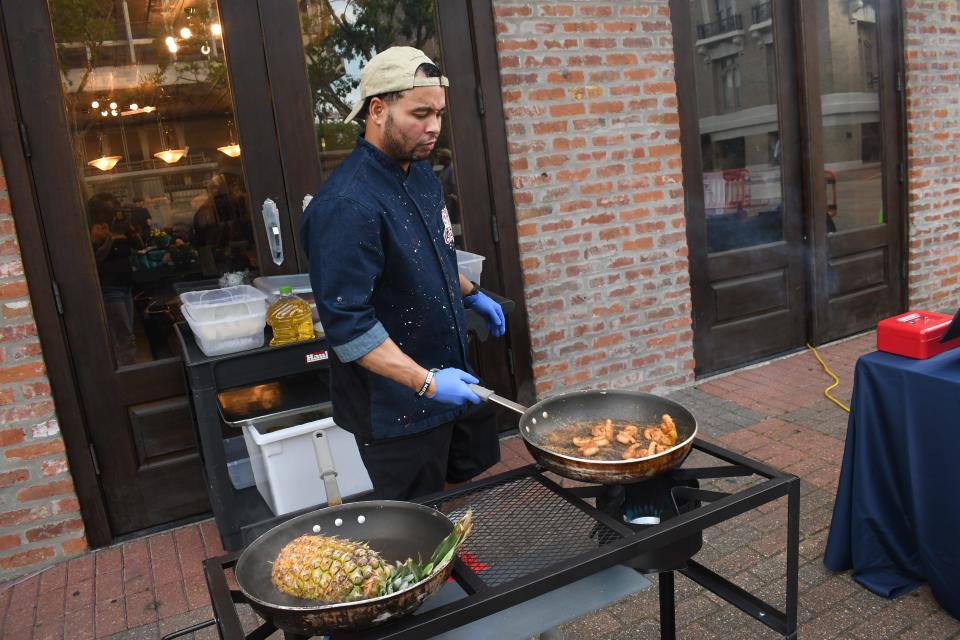 Chef Gerad Abair, Jr. of The Creole Cockpit grills up Stuffed Pineapple with Margarita Grilled Shrimp at Dinner on the Bricks. The pineapple was a bowl filled with rice, shrimp and a pineapple slice. This dish and the Pineapple with Hawaiian Grilled Salmon were popular with the crowd.