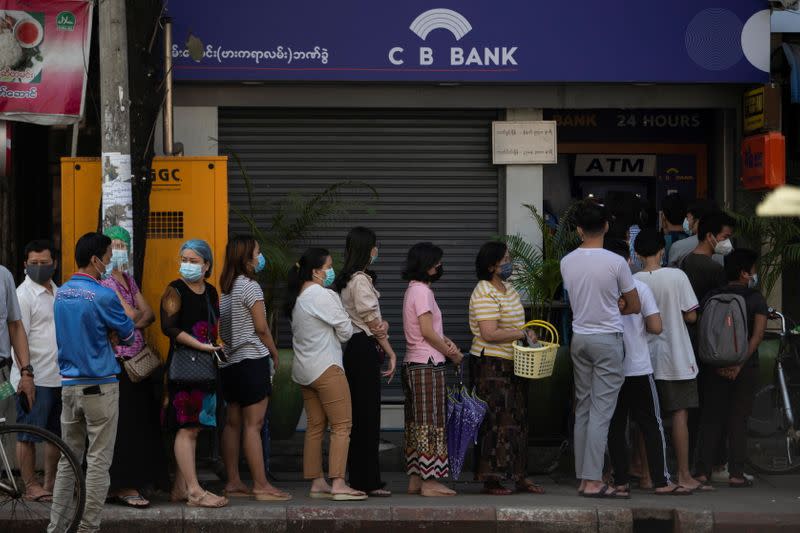 People line up outside a bank branch in Yangon