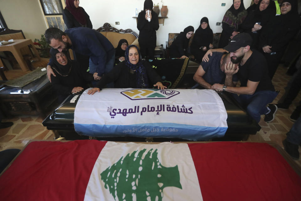 Relatives of the victims weep over the coffins in the town of Ainata, a Lebanese border village with Israel in south Lebanon, Tuesday, Nov. 7, 2023. A Lebanese woman and her three grand daughters were laid to rest in their hometown in southern Lebanon two days after they were killed in an Israeli drone strike while in a car near the Lebanon-Israel border. (AP Photo/Mohammed Zaatari)