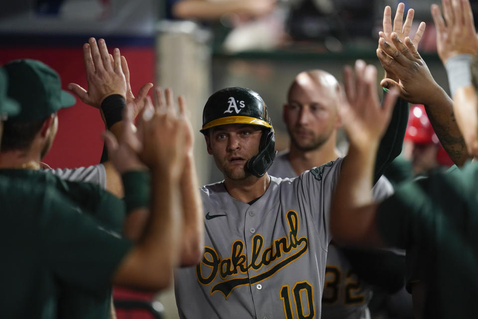 Oakland Athletics' Chad Pinder (10) celebrates in the dugout after scoring off of a single hit by Cristian Pache during the second inning of a baseball game against the Los Angeles Angels in Anaheim, Calif., Tuesday, Sept. 27, 2022. (AP Photo/Ashley Landis)