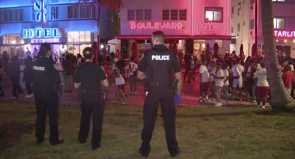 In this image taken from video, police stand guard on March 20, 2021, as crowds descend on South Beach in Miami.