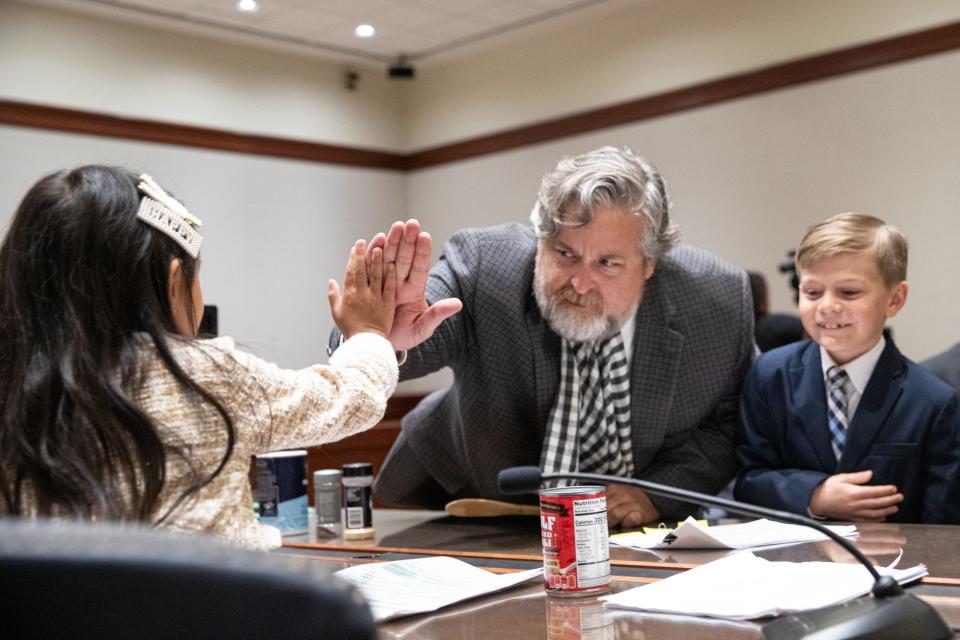 Defense lawyer Greg Turman high fives Brianna Meng, of Flour Bluff Elementary, after the team won their mock trial at the Federal Courthouse on Thursday, Nov. 16, 2023, in Corpus Christi, Texas. Alex Chappell, of East Cliff Elementary, stands next to Turman.