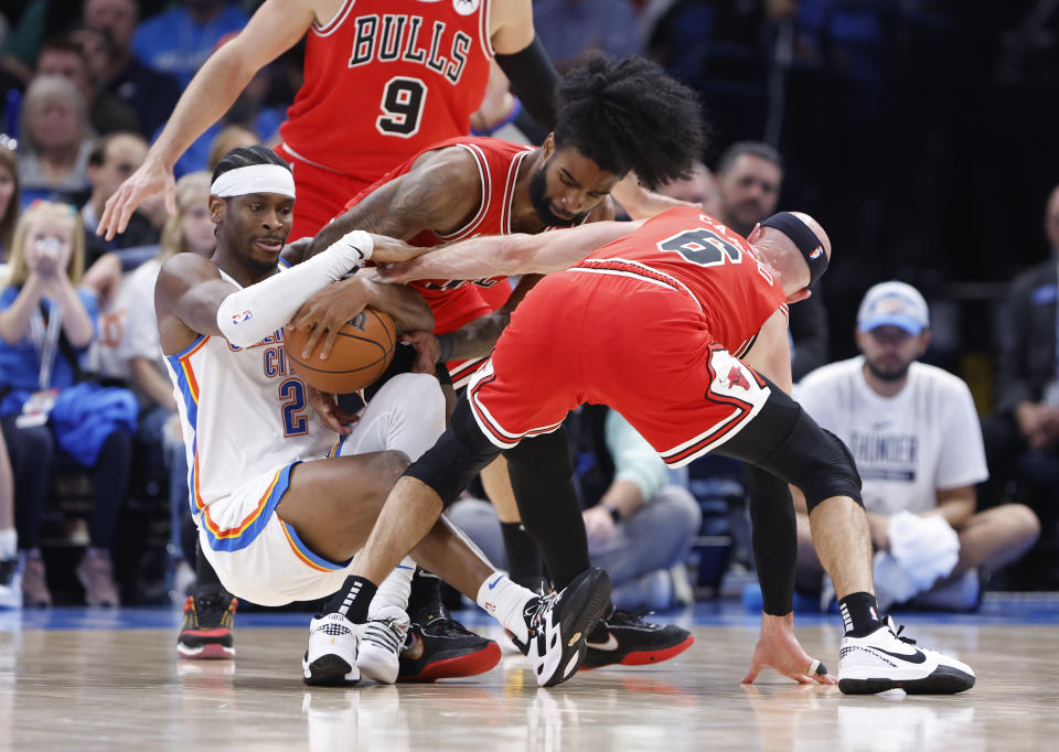 Nov 22, 2023; Oklahoma City, Oklahoma, USA; Oklahoma City Thunder guard Shai Gilgeous-Alexander (2) battles for a loose ball against Chicago Bulls guard Coby White (0) and guard Alex Caruso (6) during the second half at Paycom Center. Mandatory Credit: Alonzo Adams-USA TODAY Sports
