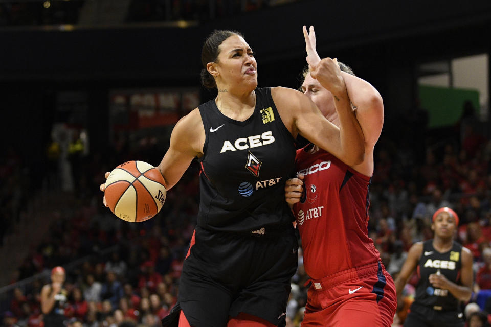 Las Vegas Aces center Liz Cambage, left, drives to the basket against Washington Mystics center Emma Meesseman during the second half of Game 2 of a WNBA playoff basketball series Thursday, Sept. 19, 2019, in Washington. Both were called for fouls. The Mystics won 103-91. (AP Photo/Nick Wass)