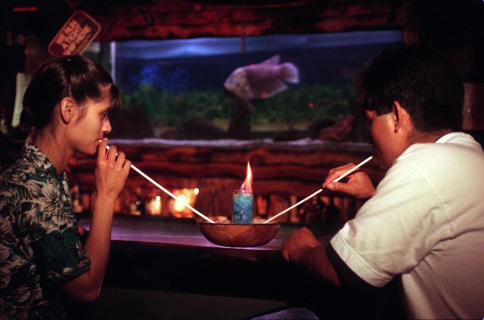 A young couple enjoy a flaming honey bowl at the Bahooka Ribs & Grog restaurant in Rosemead.