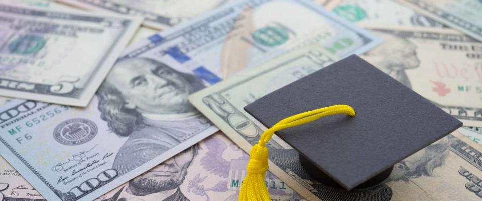 Graduation cap university or college degree on US dollars