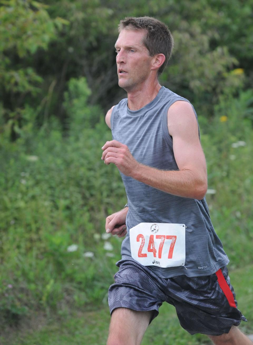 Gary Pate crosses the finish line first as the overall winner Tuesday, Aug. 9, 2022, in the Carnation 5K Trail Run at the Iron Horse Trail in Washington Township.