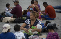 A Honduran migrant breastfeeds her daughter before starting to walk again as part of a caravan of hundreds of Honduran migrants making their way the U.S. in Esquipulas, Guatemala, early Tuesday, Oct. 16, 2018. U.S. President Donald Trump threatened on Tuesday to cut aid to Honduras if it doesn’t stop the impromptu caravan of migrants, but it remains unclear if governments in the region can summon the political will to physically halt the determined border-crossers. (AP Photo/Moises Castillo)