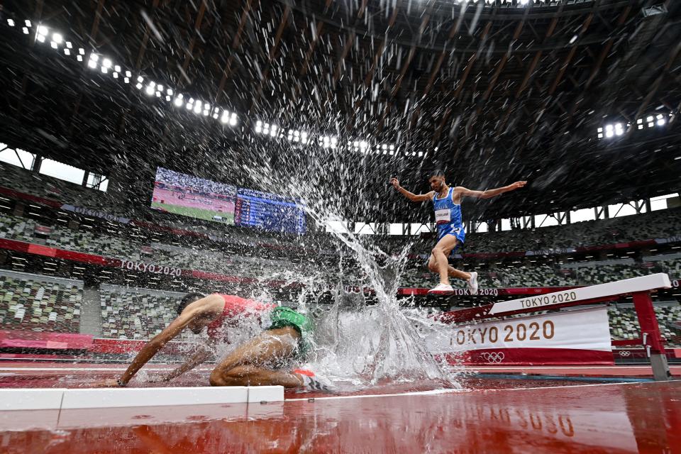 <p>Morocco's Mohamed Tindouft falls next to Italy's Ala Zoghlami while competing in the men's 3000m steeplechase heats during the Tokyo 2020 Olympic Games at the Olympic Stadium in Tokyo on July 30, 2021. (Photo by Andrej ISAKOVIC / AFP)</p> 