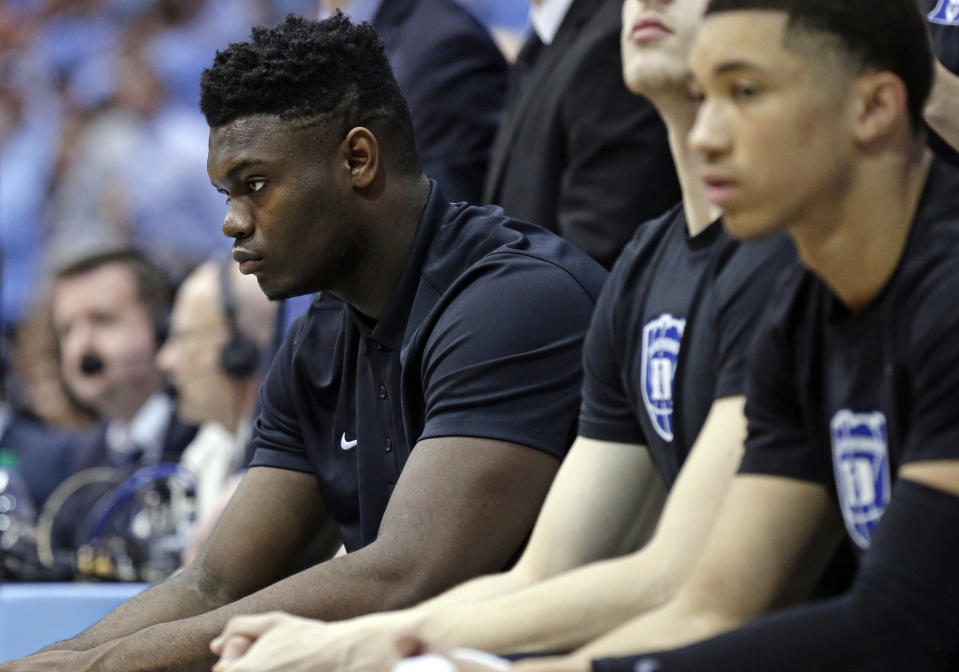 Injured Duke player Zion Williamson, left, sits on the bench during the first half of an NCAA college basketball game against North Carolina in Chapel Hill, N.C., Saturday, March 9, 2019. (AP Photo/Gerry Broome)