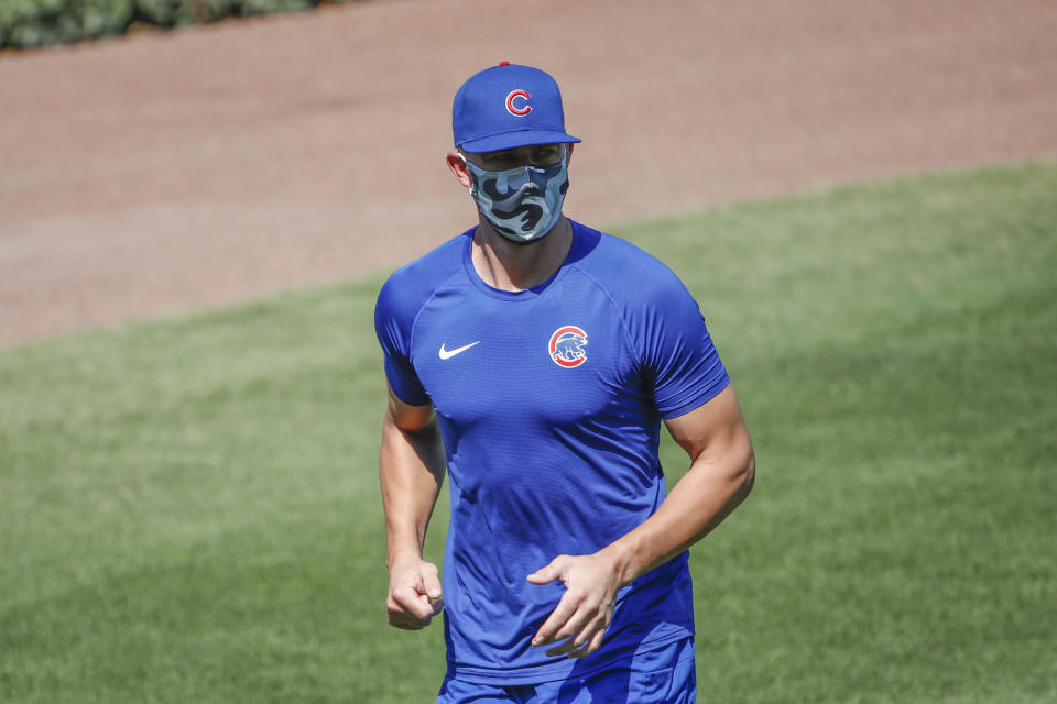 Kris Bryant, tercera base de los Cachorros de Chicago, calienta portando un cubrebocas durante una sesión de práctica en el Wrigley Field el domingo 5 de julio de 2020, en Chicago. (AP Foto/Kamil Krzaczynski)