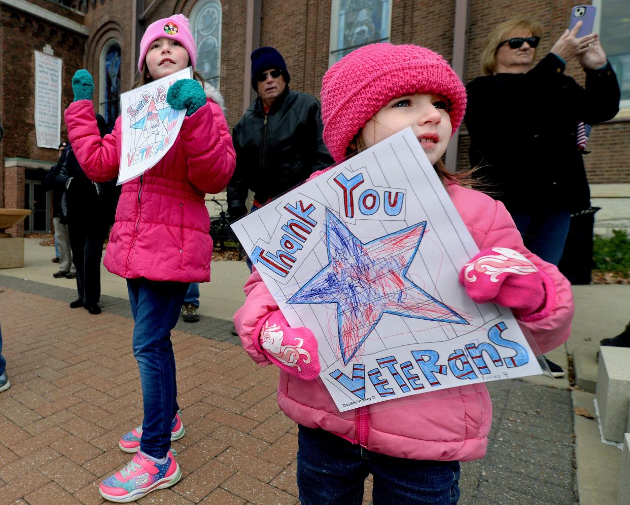 Horacek Finley, 4, of Springfield, right, and her sister, Adalynn, hold up signs thanking veterans at the Springfield Veterans Day parade along Capitol Avenue Friday Nov. 11, 2022.