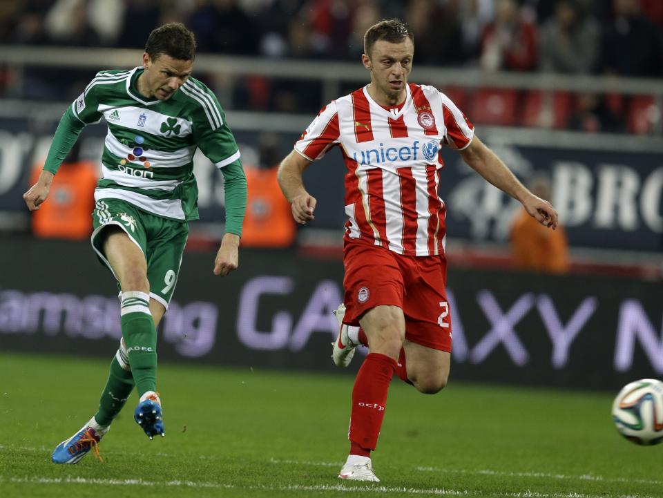 Panathinaikos' Marcus Berg, left, scores his team's second goal as Olympiakos' Avraam Papadopoulos looks the ball during a Greek League soccer match at Georgios Karaiskakis stadium, in Piraeus port, near Athens, on Sunday, March 2, 2014. (AP Photo/Thanassis Stavrakis)