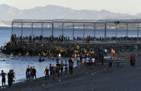 People from Morocco swim and walk into the Spanish territory at the border of Morocco and Spain, at the Spanish enclave of Ceuta on Monday, May 17, 2021. Authorities in Spain say that around 1,000 Moroccan migrants have crossed into Spanish territory (Antonio Sempere/Europa Press via AP)