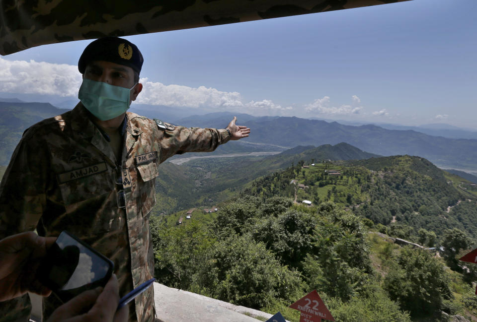 An army officer briefs journalists at a hilltop post in Chiri Kot sector near Line of Control, that divides Kashmir between Pakistan and India, Wednesday, July 22, 2020. Villagers living along a highly militarized frontier in the disputed region of Kashmir have accused India of "intentionally targeting" civilians, but they are vowing that they would never leave their areas. Villagers say the fear of death is no longer present in their hearts after spending so many years in a state of shock and uncertainty. (AP Photo/Anjum Naveed)