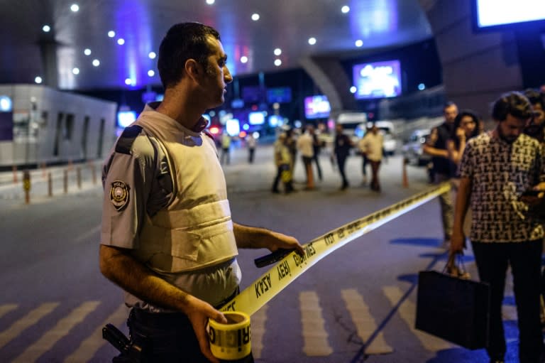 A policeman sets up a security perimeter as people leave the airport after two explosions followed by gunfire hit the Turkey's biggest airport of Ataturk in Istanbul, on June 28, 2016. At least 10 people were killed on June 28, 2016