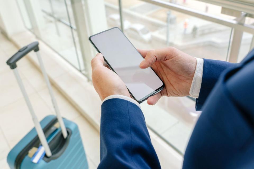 <p>Getty</p> Stock image of a traveler using a smartphone