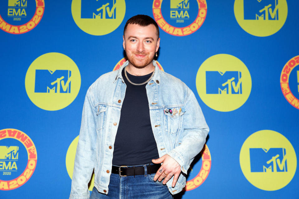 Sam with their hand on their hip for a red carpet photo