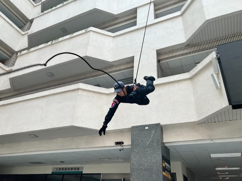 高雄特勤中隊受邀演出 市府中庭垂降操演 高雄市警察局特勤中隊受少年警察隊青春專案7月6日 活動邀請演出，人員23日全副武裝在市府四維行政中 心1樓中庭操演，項目包含座位式下降、正面式下降 及反劫持等。 中央社記者張已亷攝  113年6月23日 