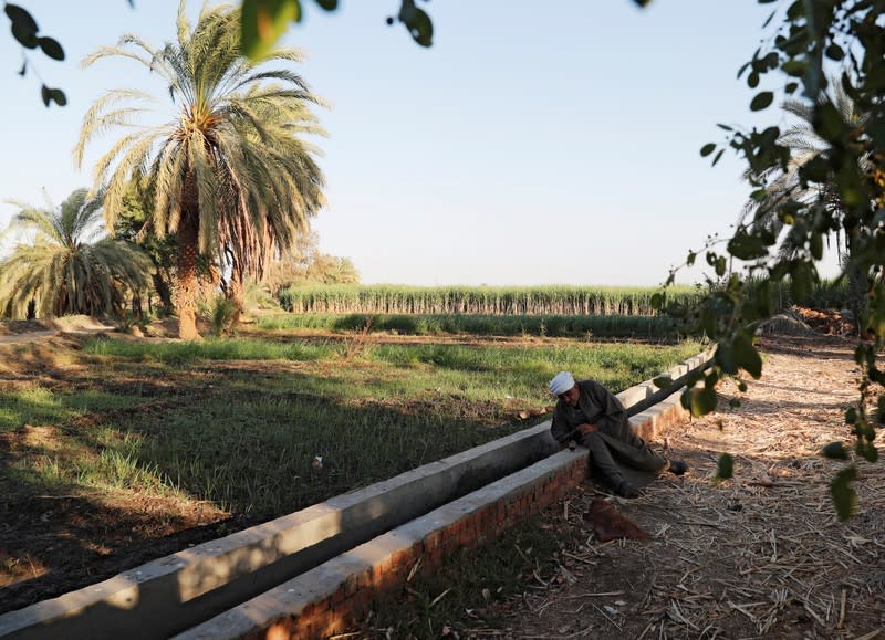 Abdel-Shaheed Gerges, a farmer, touches water at an irrigation channel developed by a government project in Comer village in Esna, south of Luxor