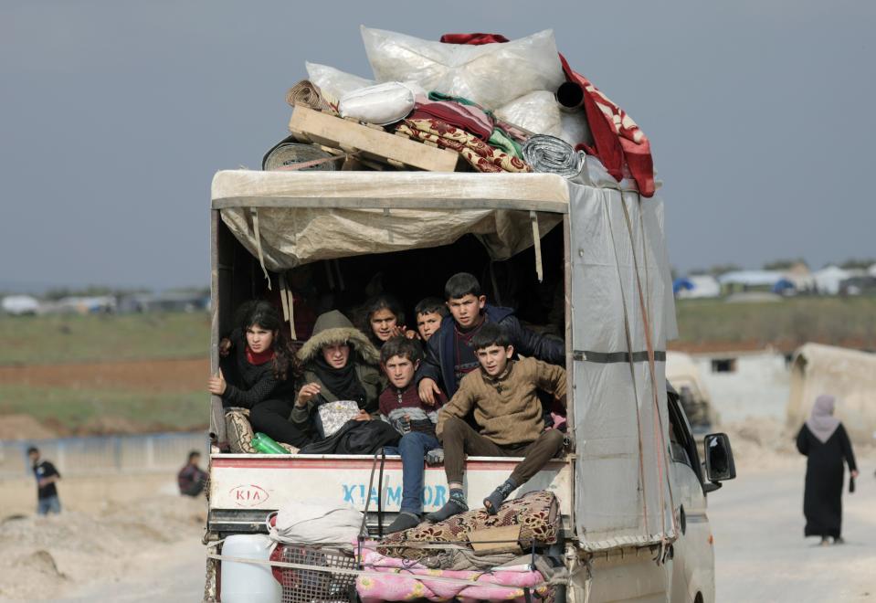FILE PHOTO: Internally displaced children ride in a pick up truck with their belongings in Afrin, Syria February 18, 2020. REUTERS/Khalil Ashawi