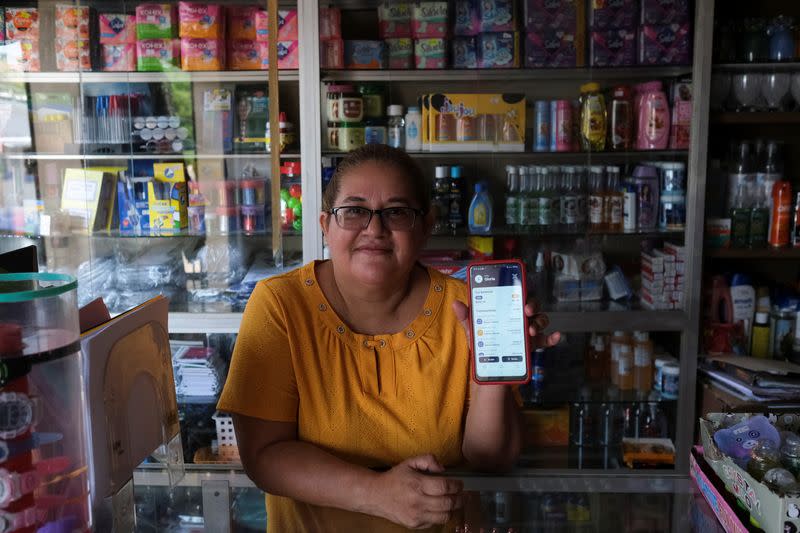 Gloria Barcia muestra su cartera de Bitcoin en su tienda en la ciudad de Conchagua, cerca del sitio proyectado para la Ciudad Bitcoin según el presidente de El Salvador, Nayib Bukele, en Conchagua