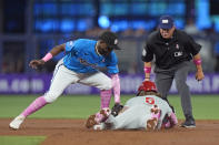 Miami Marlins shortstop Vidal Brujan, left, attempts to tag Philadelphia Phillies' Bryson Stott (5) as Stott steals second base during the first inning of a baseball game, Sunday, May 12, 2024, in Miami. (AP Photo/Wilfredo Lee)