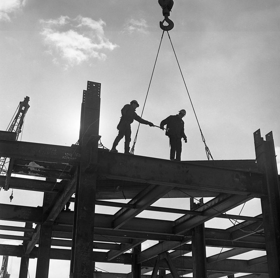 In this undated photo provided by the National Museum of Industrial History, construction workers help guide a girder into place during the construction of Martin Tower in Bethlehem, Pa. The 21-story building, the former global headquarters of defunct steelmaker Bethlehem Steel Corp., is set to be imploded on May 19, 2019. (National Museum of Industrial History via AP)