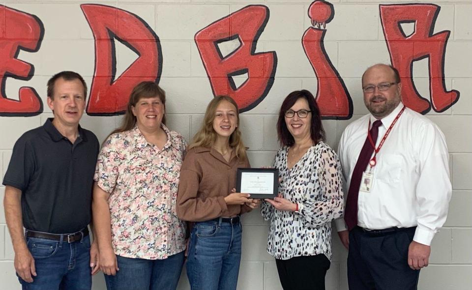 Jenna Book (center) accepts a plaque declaring her a Commended Student through the National Merit Scholarship Program from Loudonville High School Principal Chrissy Bash. Book said her parents, Jamie and Jill Book, who are beside her, supported her throughout high school and have been very supportive of her college plans as well.