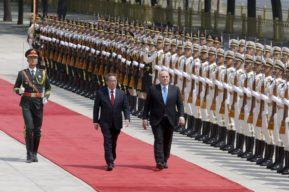 Russian Prime Minister Mikhail Mishustin, right, and Chinese Premier Li Qiang attend a welcoming ceremony in Beijing, China, Wednesday, May 24, 2023. (Thomas Peter/Pool Photo via AP)