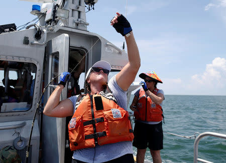 College of Charleston faculty member Cynthia Hall helps pull in a balloon during a test for the Space Grant Ballooning Project in preparations for Monday's solar eclipse on board a US Coast Guard response boat at sea near Charleston, South Carolina, U.S. August 17, 2017. Location coordinates for this image are 32º41' 975" N 79º44'195" W. REUTERS/Randall Hill