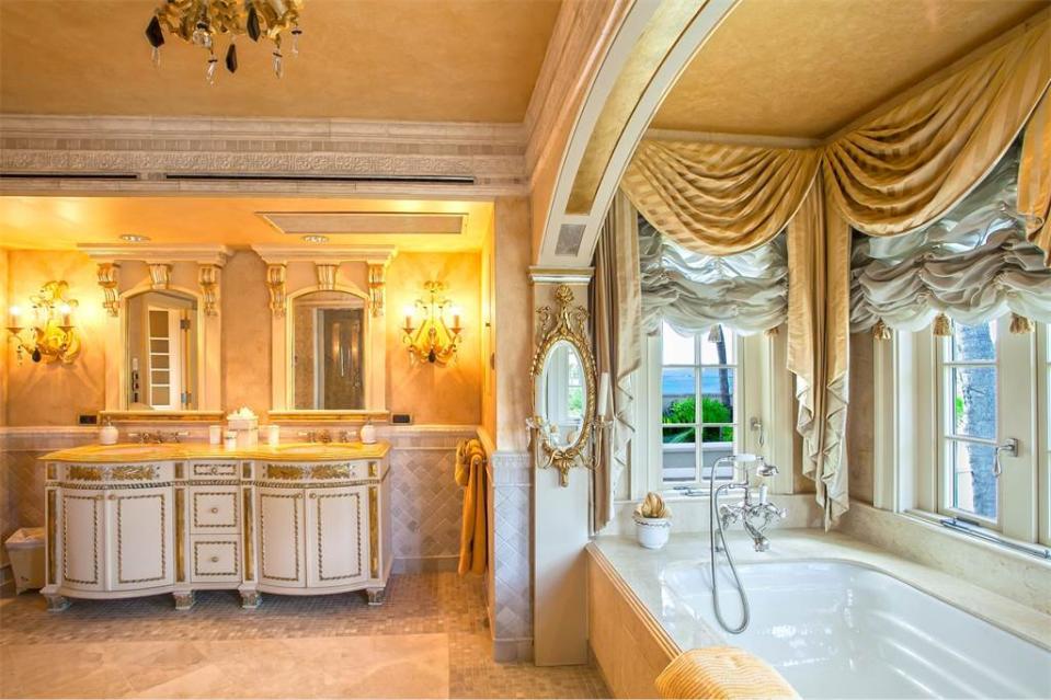 <p>La salle de bain de style classique n’oublie pas les dorures et le lustre. Tony Montana aurait pu y vivre apparement. (Photo : Sotheby’s International Realty) </p>