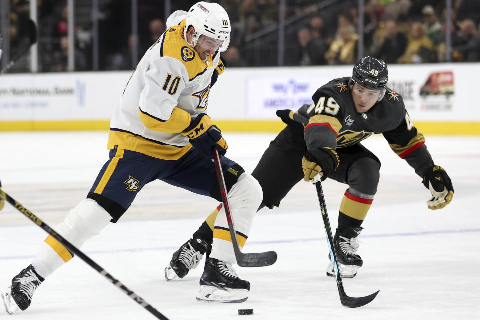 Nashville Predators center Colton Sissons (10) skates with the puck while Vegas Golden Knights center Ivan Barbashev (49) reaches to defend during the first period of an NHL hockey game Monday, Jan. 15, 2024, in Las Vegas. (AP Photo/Ellen Schmidt)